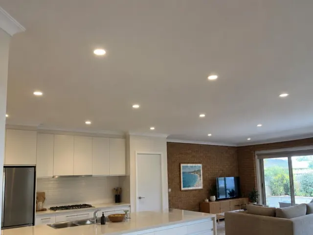 Open-plan home interior with recessed LED downlights in a kitchen and living area in Curl Curl